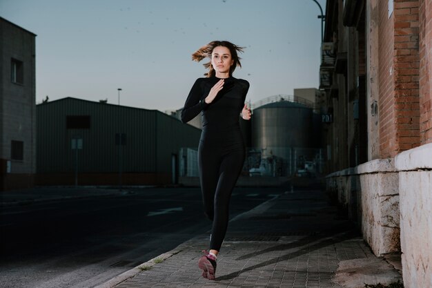 Mujer seria corriendo con determinación en la calle