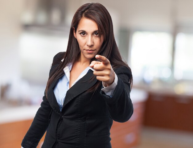 Mujer seria elegante señalando al frente