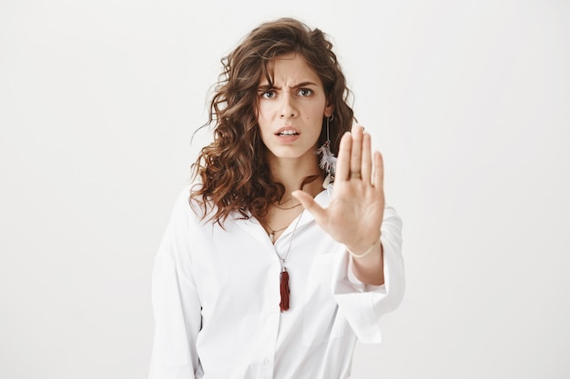 Mujer seria enojada mostrando gesto de parada, en desacuerdo y prohibir la acción