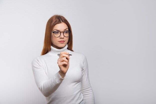 Mujer seria escribiendo algo en el aire