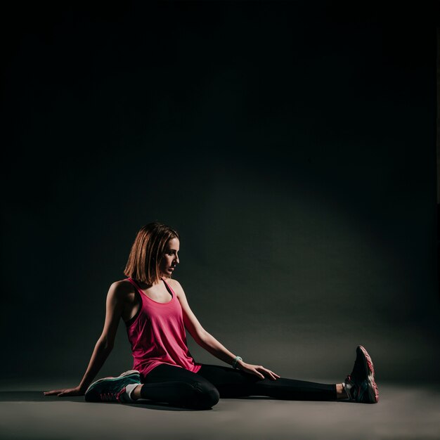 Mujer seria flexionando en estudio