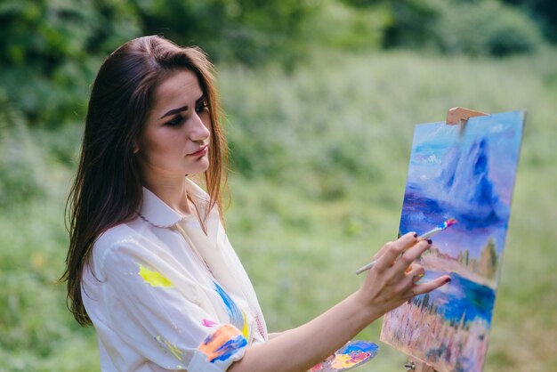 Mujer seria pintando un cuadro