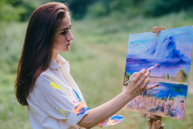 Mujer seria pintando un cuadro
