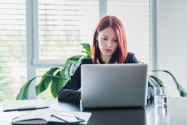 Mujer seria con portátil en la oficina