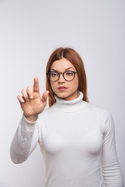 Mujer seria presionando el botón virtual