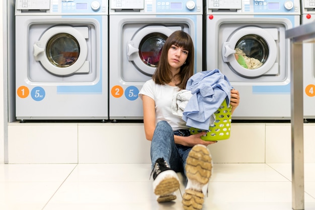 Mujer seria que sostiene la cesta de lavadero