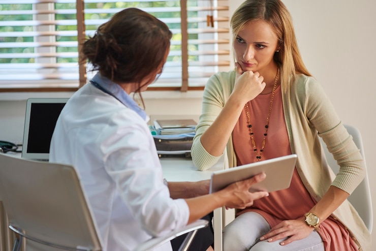 Foto gratuito mujer seria durante su visita al médico
