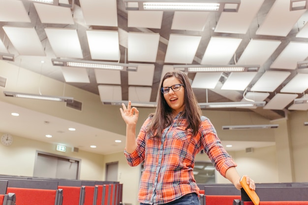 Foto gratuita mujer con signo bien en sala de conferencias