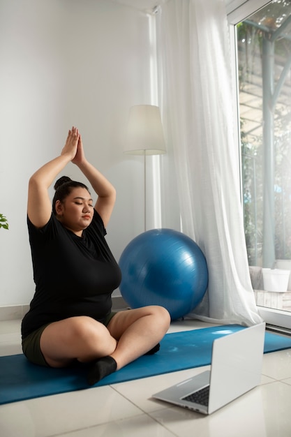 Mujer siguiendo instructor de fitness en línea