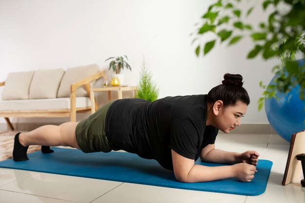 Mujer siguiendo instructor de fitness en línea