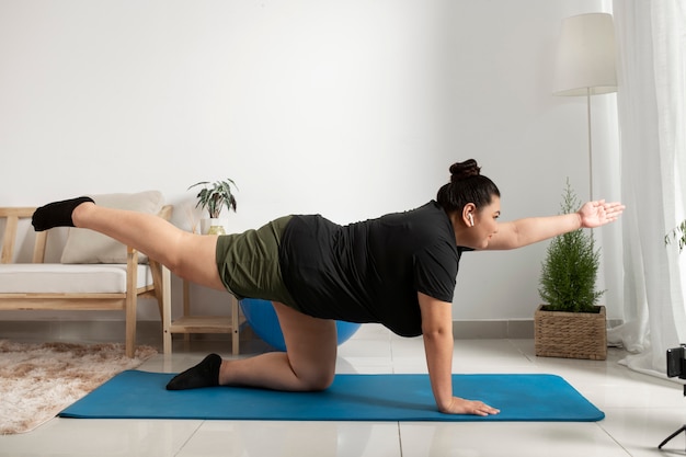 Mujer siguiendo instructor de fitness en línea