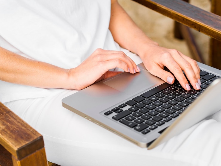Foto gratuito mujer en silla trabajando en la computadora portátil