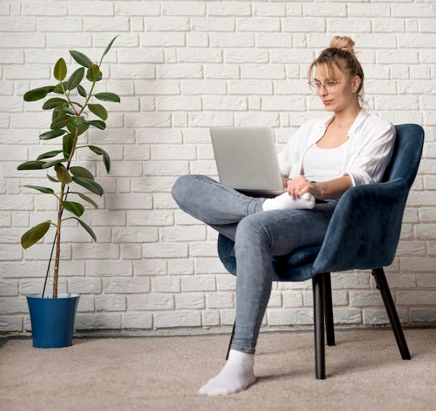 Mujer en silla trabajando en laptop