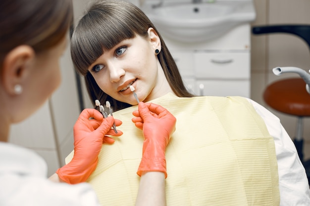 Mujer en un sillón dental. chica elige un implante. bbeauty trata sus dientes