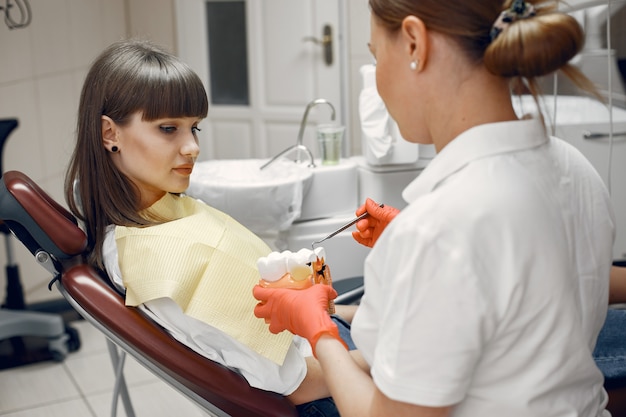 Mujer en un sillón dental. El dentista enseña el cuidado adecuado.La belleza trata sus dientes