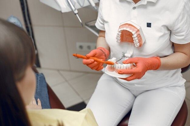 Mujer en un sillón dental. El dentista enseña el cuidado adecuado.La belleza trata sus dientes