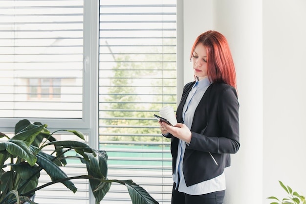 Mujer con smartphone y café