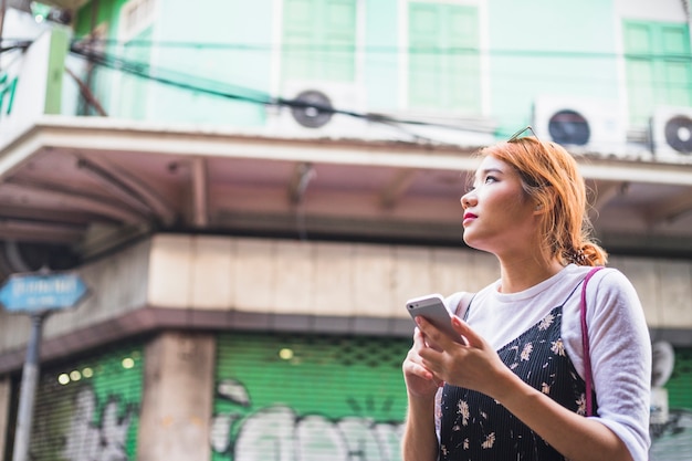 Foto gratuita mujer con smartphone en la calle