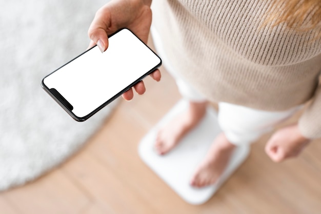 Mujer con smartphone junto a balanza tecnología innovadora