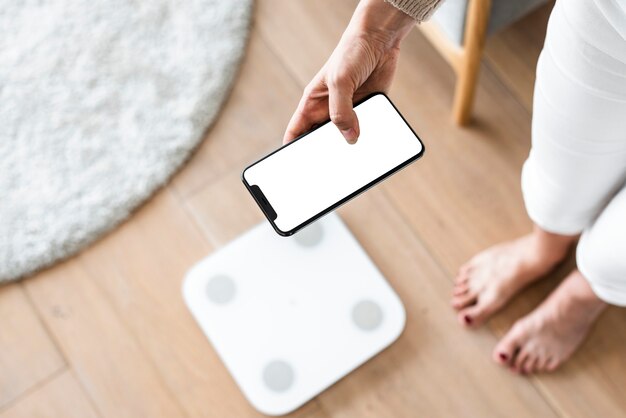 Mujer con smartphone junto a balanza tecnología innovadora