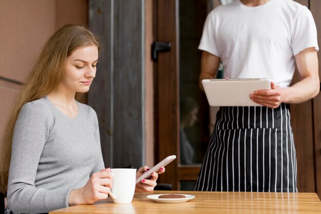 Mujer con smartphone pidiendo café