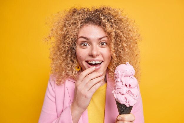 mujer smilesbroadly se divierte escucha noticias emocionantes disfruta del horario de verano tiene delicioso helado de cono grande vestido formalmente