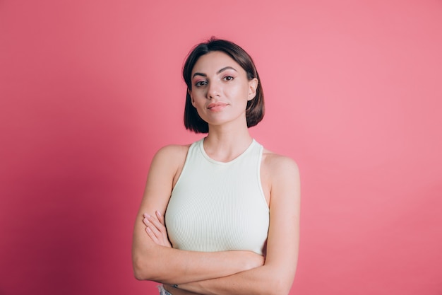 Mujer sobre fondo rosa cara feliz sonriendo mirando a la cámara. Persona positiva.