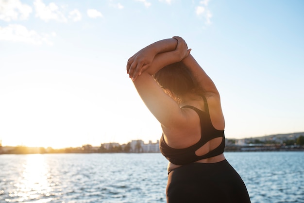 Mujer con sobrepeso haciendo ejercicio al aire libre junto al lago