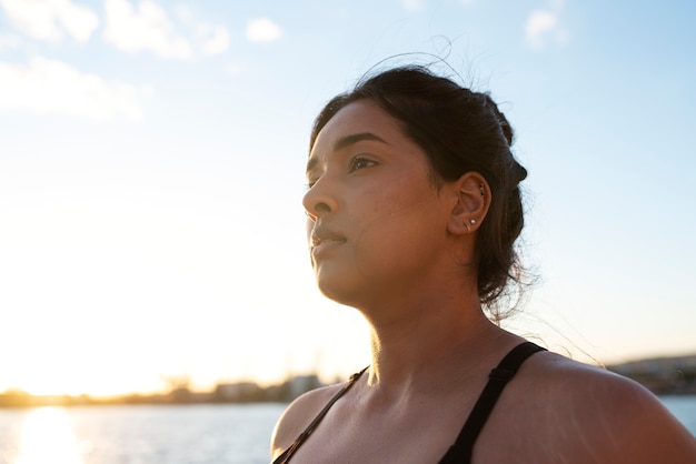 Foto gratuita mujer con sobrepeso haciendo ejercicio al aire libre junto al lago