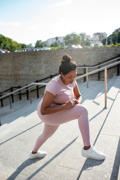 Mujer con sobrepeso haciendo ejercicio en las escaleras al aire libre