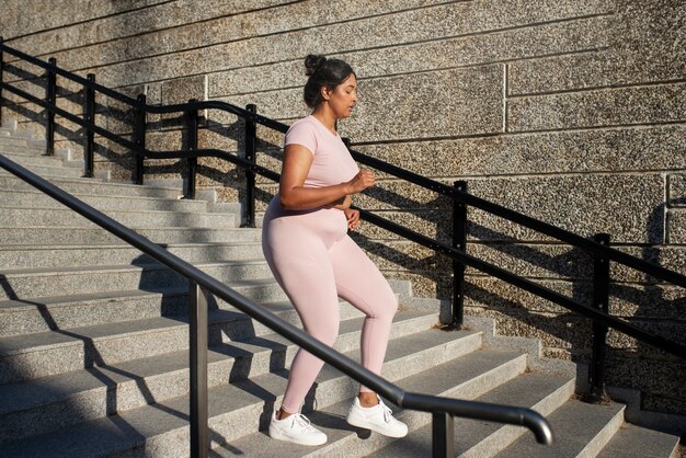 Mujer con sobrepeso haciendo ejercicio en las escaleras al aire libre