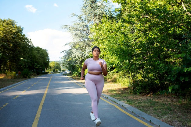 Foto gratuita mujer con sobrepeso trotar al aire libre