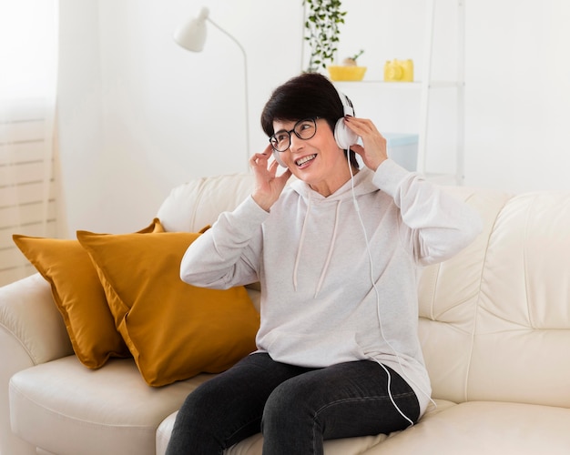 Mujer en el sofá en casa escuchando música