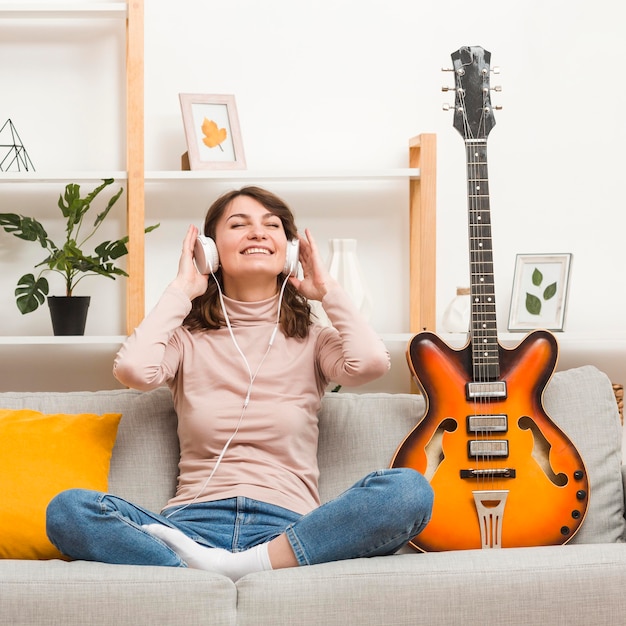 Foto gratuita mujer en sofá con guitarra