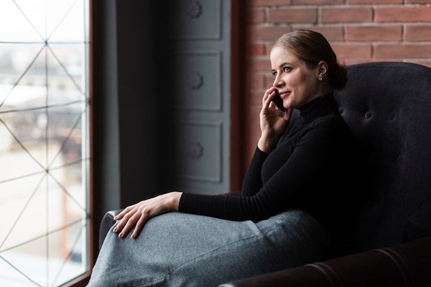 Foto gratuita mujer en el sofá hablando por teléfono