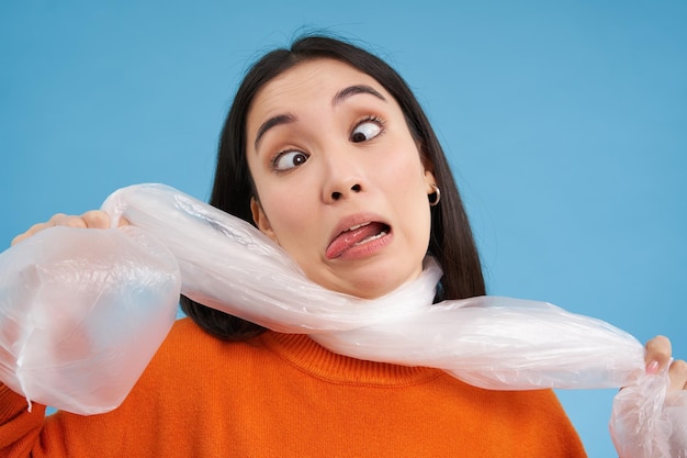 Foto gratuita mujer sofocante siendo asfixiada por el concepto de bolsa de plástico del medio ambiente ecológico y el reciclaje de la espalda azul