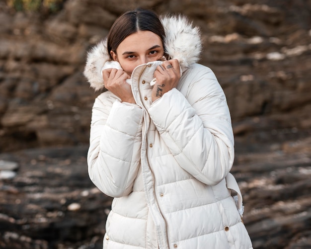 Mujer sola en la playa con chaqueta de invierno