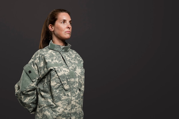 Foto gratuita mujer soldado de pie a gusto postura militar