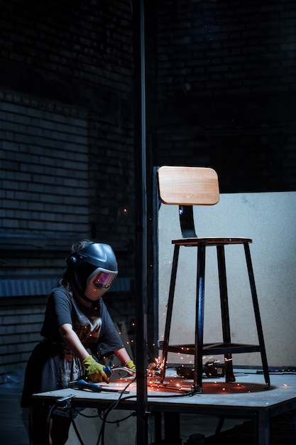 Foto gratuita mujer soldador que trabaja en el taller