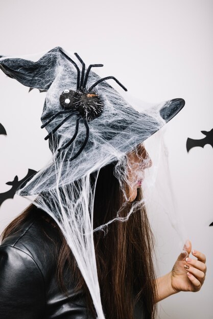 Mujer en sombrero adornado de Halloween