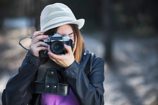 Mujer con sombrero blanco tomando fotos