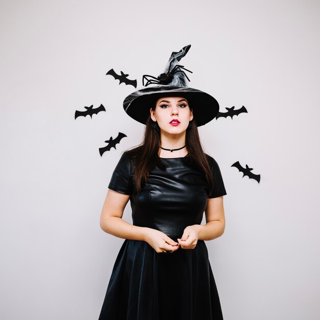 Mujer en sombrero de bruja en murciélagos