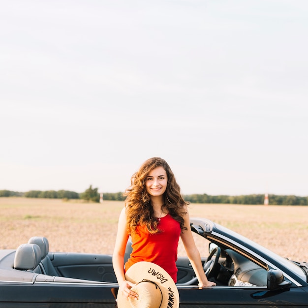 Foto gratuita mujer con sombrero cerca del coche