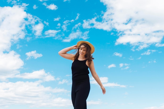 Foto gratuita mujer con sombrero y cielo con nubes