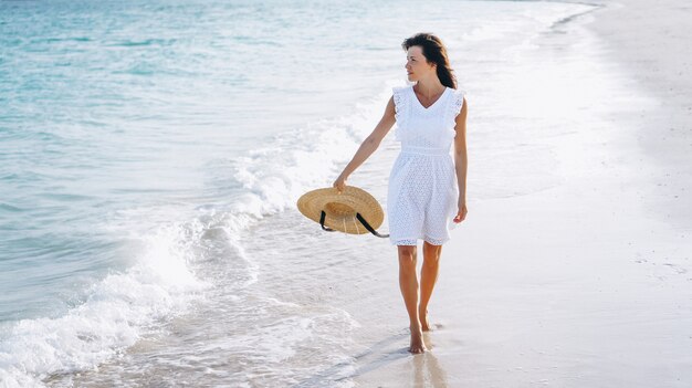 Mujer con sombrero en la costa del océano Índico