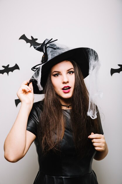Mujer en el sombrero de Halloween en estudio