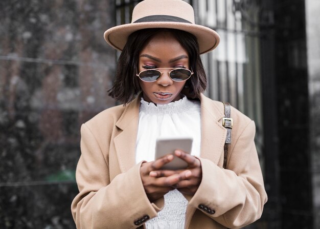 Mujer con sombrero mirando su teléfono