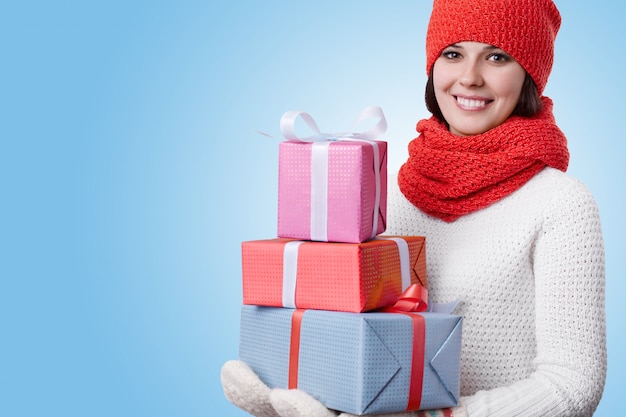 Foto gratuita mujer con sombrero rojo con bufanda suéter blanco y guantes cálidos ser feliz con muchos regalos en sus manos