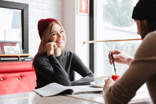 Mujer con sombrero rojo hablando con hombre