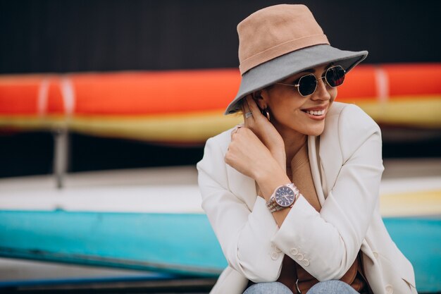 Mujer con sombrero sonriendo y usando teléfono